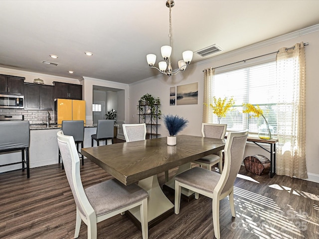 dining area with dark hardwood / wood-style floors, an inviting chandelier, and crown molding