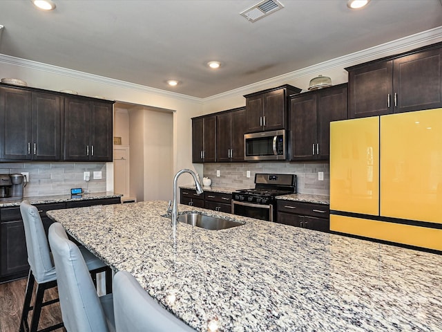 kitchen featuring tasteful backsplash, light stone countertops, sink, and stainless steel appliances