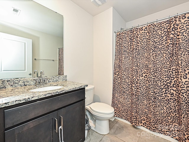 bathroom featuring tile patterned flooring, vanity, and toilet