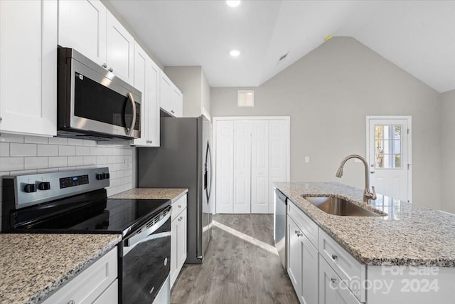 kitchen with sink, light hardwood / wood-style floors, a kitchen island with sink, white cabinets, and appliances with stainless steel finishes