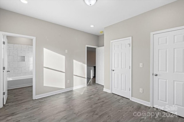 unfurnished bedroom featuring dark wood-type flooring and connected bathroom