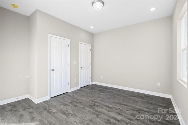 unfurnished bedroom with dark wood-type flooring