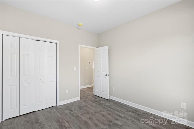 unfurnished bedroom featuring dark hardwood / wood-style flooring and a closet