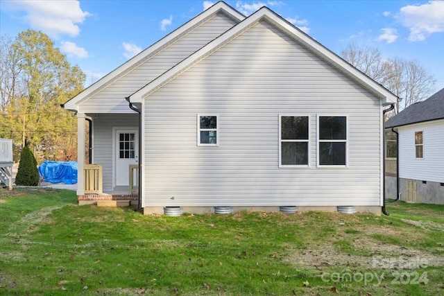 rear view of house featuring a yard