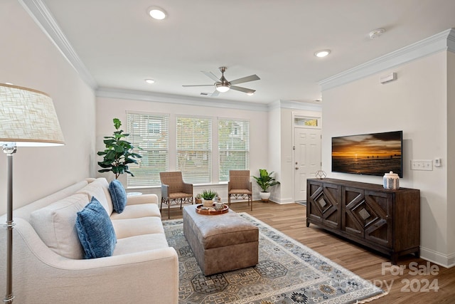 living room with light hardwood / wood-style flooring, ceiling fan, and ornamental molding