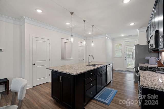 kitchen featuring a kitchen island with sink, sink, light stone countertops, and appliances with stainless steel finishes