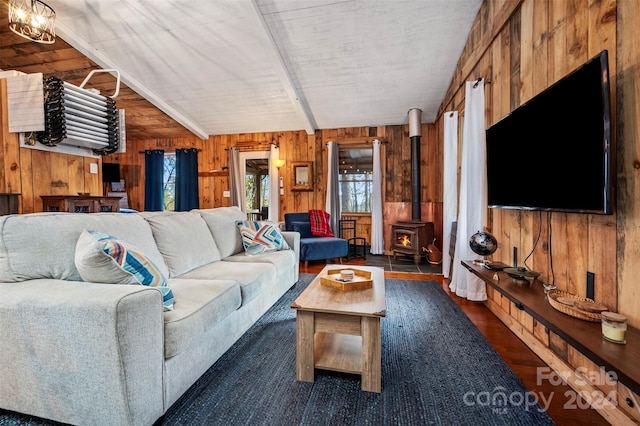 living room with a wood stove, wooden walls, dark hardwood / wood-style flooring, and lofted ceiling with beams