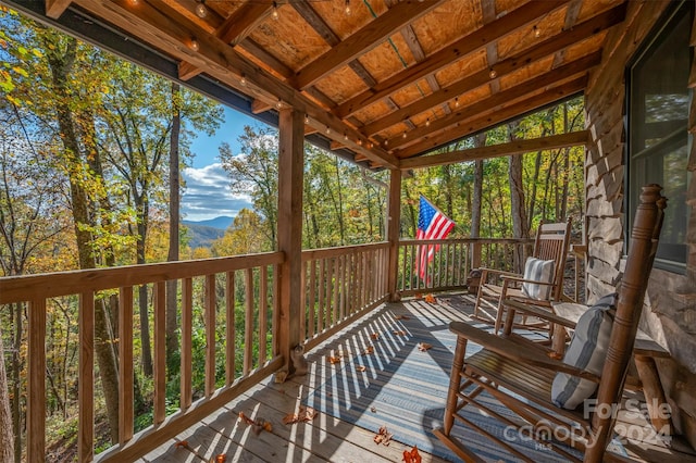 unfurnished sunroom with vaulted ceiling with beams