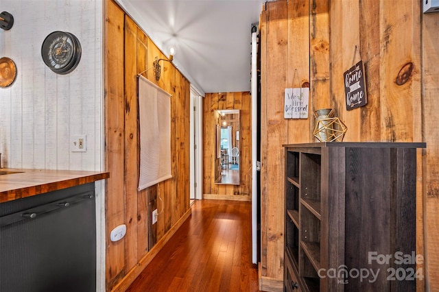 hall featuring wood walls and dark hardwood / wood-style flooring