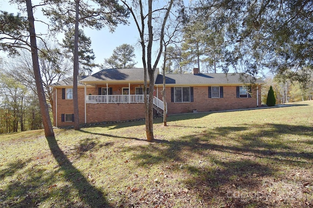 rear view of house featuring a yard and a porch