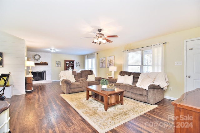 living room with a fireplace, ceiling fan, dark hardwood / wood-style flooring, and a healthy amount of sunlight