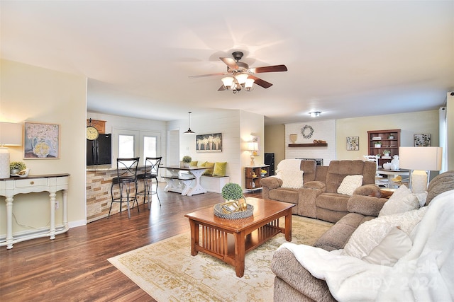 living room featuring a fireplace, french doors, ceiling fan, and dark wood-type flooring