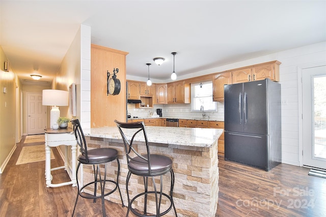 kitchen with a wealth of natural light, black fridge, sink, and dark hardwood / wood-style floors