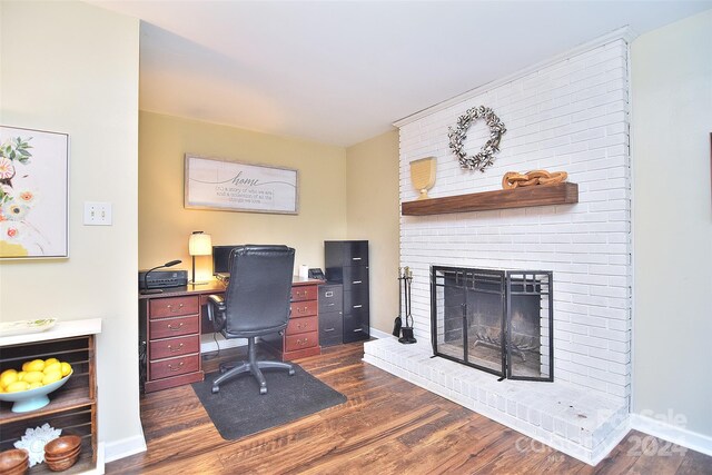 office area with a fireplace and dark wood-type flooring