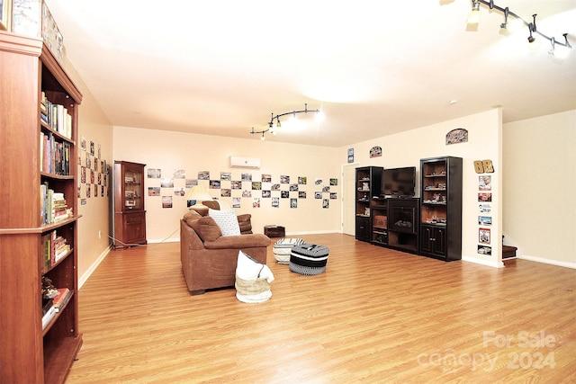 living room featuring rail lighting and light hardwood / wood-style floors