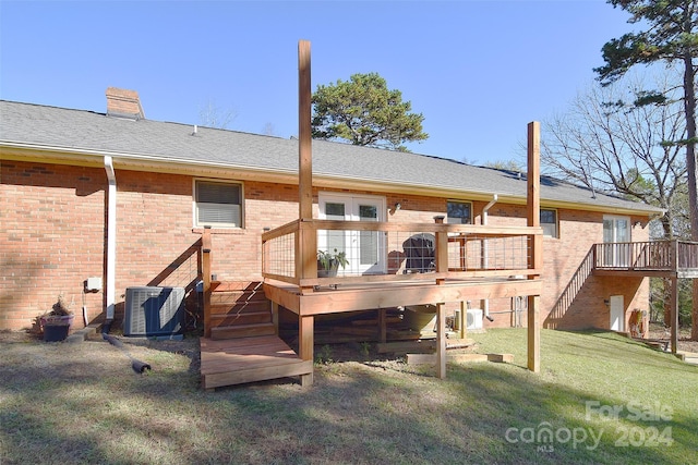 rear view of property with a wooden deck, a yard, and central AC unit