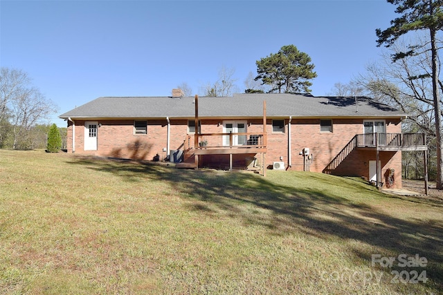 rear view of property featuring a deck and a yard