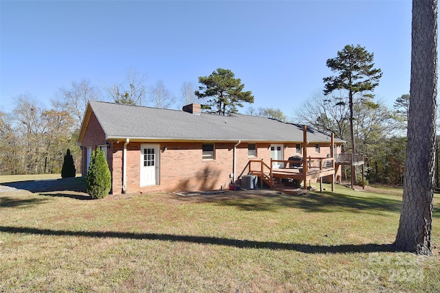 back of property featuring a yard, cooling unit, and a deck