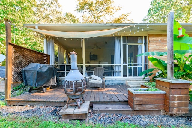 wooden deck featuring a grill and a sunroom