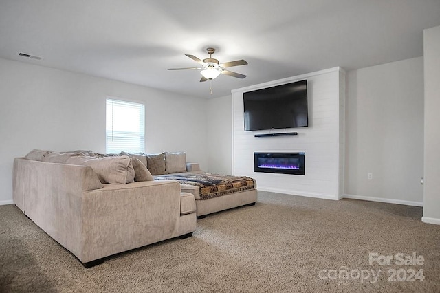 living room featuring a large fireplace, carpet floors, and ceiling fan