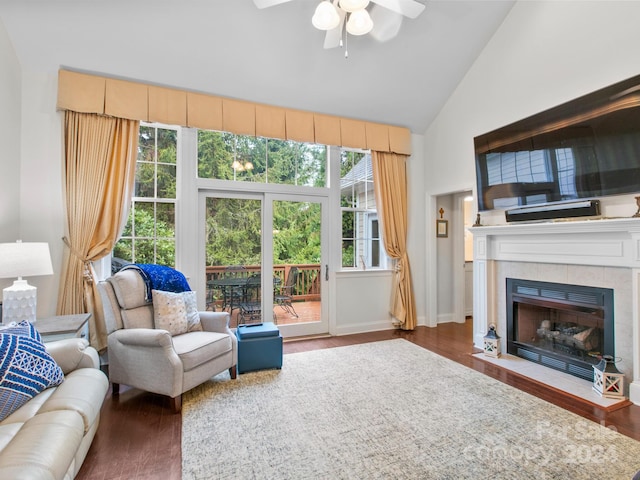 interior space with dark hardwood / wood-style floors, ceiling fan, a fireplace, and high vaulted ceiling