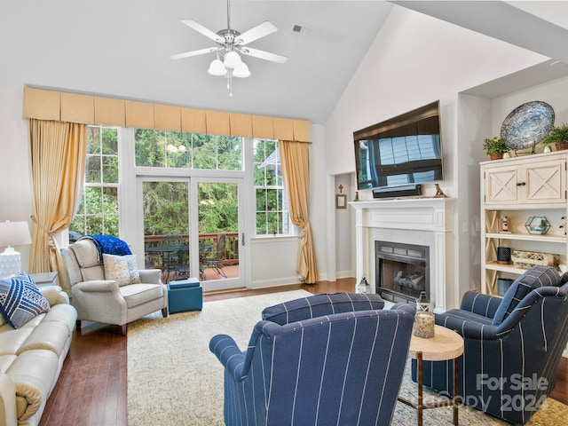 living room with ceiling fan, dark hardwood / wood-style flooring, a fireplace, and high vaulted ceiling