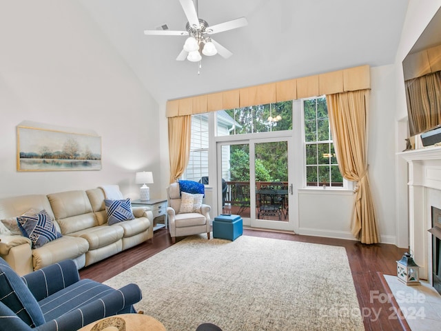 living room featuring ceiling fan, dark hardwood / wood-style flooring, high vaulted ceiling, and a healthy amount of sunlight