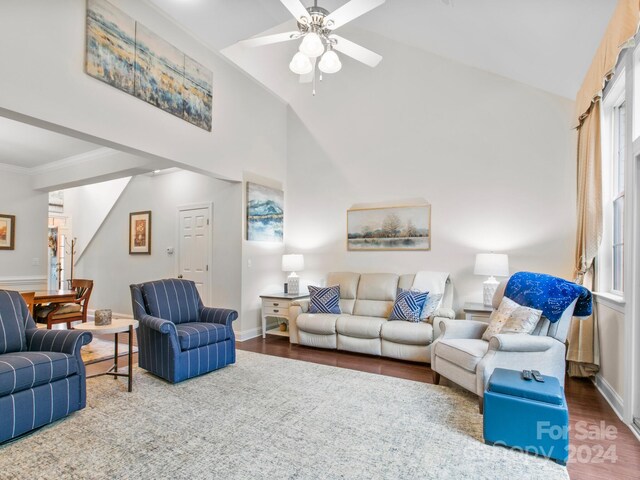 living room with hardwood / wood-style flooring, ceiling fan, and vaulted ceiling