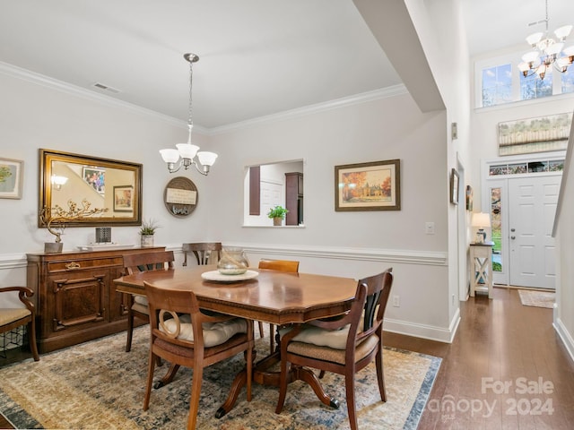 dining area featuring dark hardwood / wood-style floors, crown molding, and a chandelier