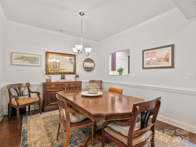 dining area with crown molding, dark wood-type flooring, and a notable chandelier