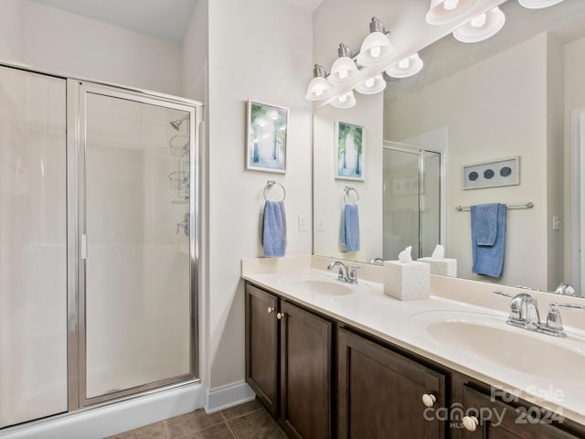 bathroom featuring tile patterned flooring, vanity, and walk in shower