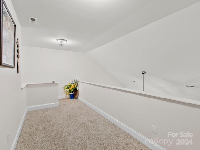 hall with carpet floors and lofted ceiling