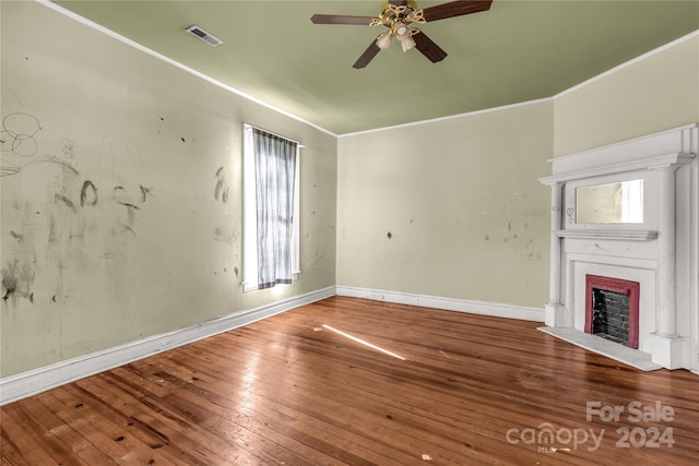 unfurnished living room featuring hardwood / wood-style floors, ornamental molding, and ceiling fan