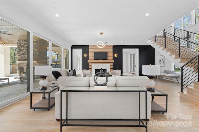 living room with a high end fireplace and light wood-type flooring