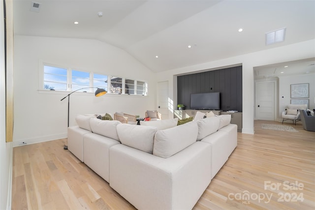 living room featuring light wood-type flooring and vaulted ceiling