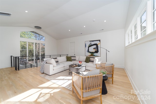 living room featuring light wood-type flooring and vaulted ceiling