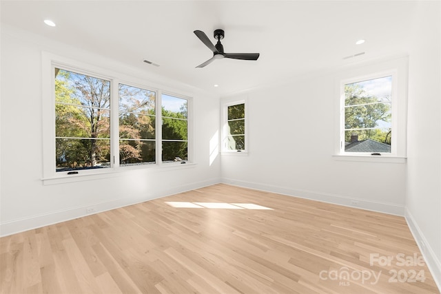 unfurnished room featuring ceiling fan, a healthy amount of sunlight, and light hardwood / wood-style flooring