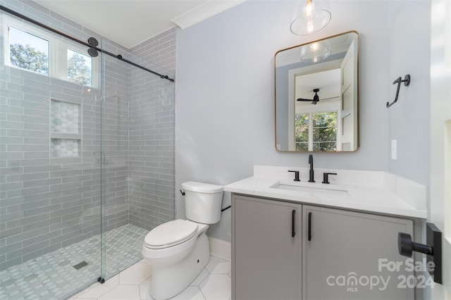 bathroom with tile patterned floors, vanity, toilet, and a shower with shower door