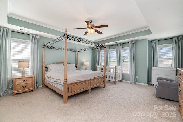 carpeted bedroom featuring ceiling fan, a raised ceiling, and crown molding