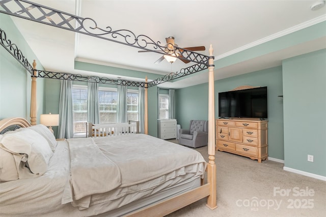 carpeted bedroom featuring a tray ceiling, ceiling fan, and ornamental molding