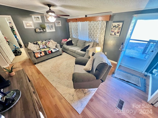 living room featuring crown molding, hardwood / wood-style floors, ceiling fan, and a textured ceiling