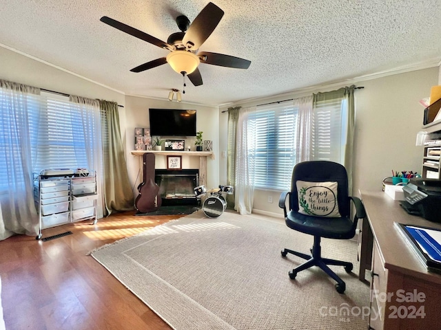 office area featuring hardwood / wood-style flooring, ceiling fan, a textured ceiling, and ornamental molding