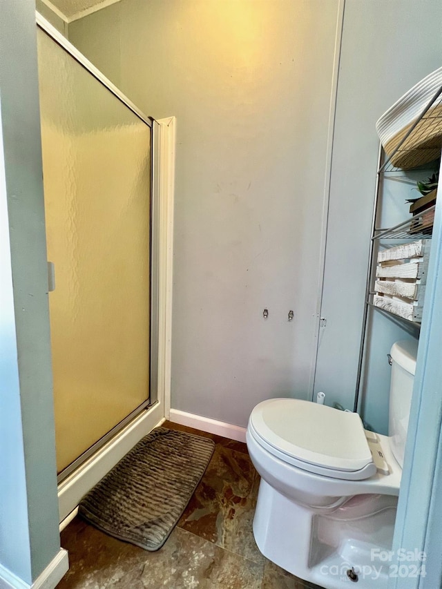 bathroom featuring an enclosed shower and toilet