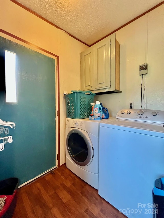 washroom featuring washing machine and dryer, cabinets, a textured ceiling, and dark hardwood / wood-style floors