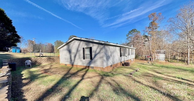 940 Devil Track Rd, Taylorsville, NC 28681 - view of side of home with crawl space, a trampoline, a yard, and central AC