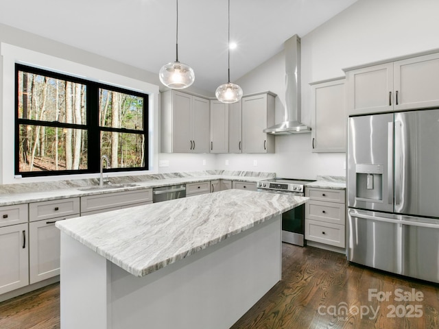 kitchen featuring a kitchen island, decorative light fixtures, light stone counters, stainless steel appliances, and wall chimney range hood