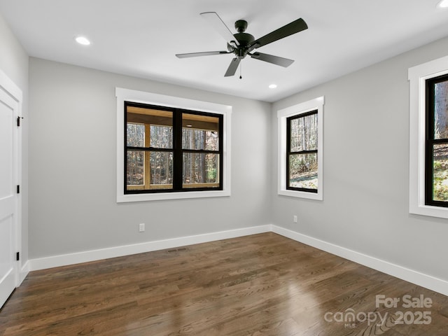 spare room with dark hardwood / wood-style floors and ceiling fan