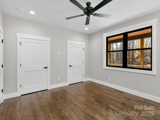 unfurnished bedroom featuring dark hardwood / wood-style floors and ceiling fan