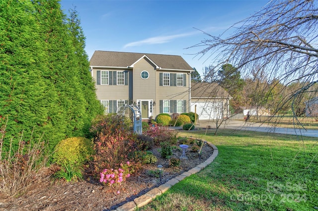 colonial home featuring a garage and a front yard