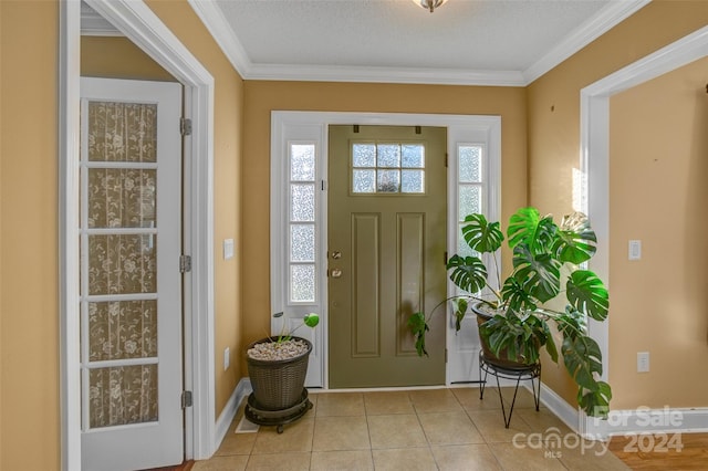 foyer entrance with light tile patterned floors, a textured ceiling, and crown molding